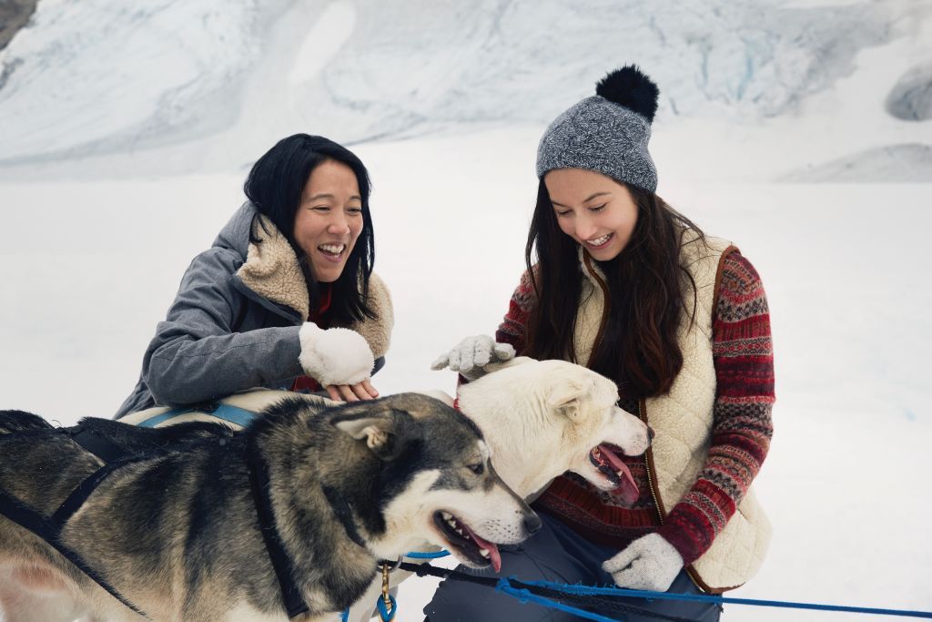 Close up of two girls with huskies