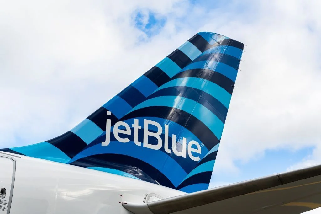 JetBlue A220 aircraft tail with blue stripy colors