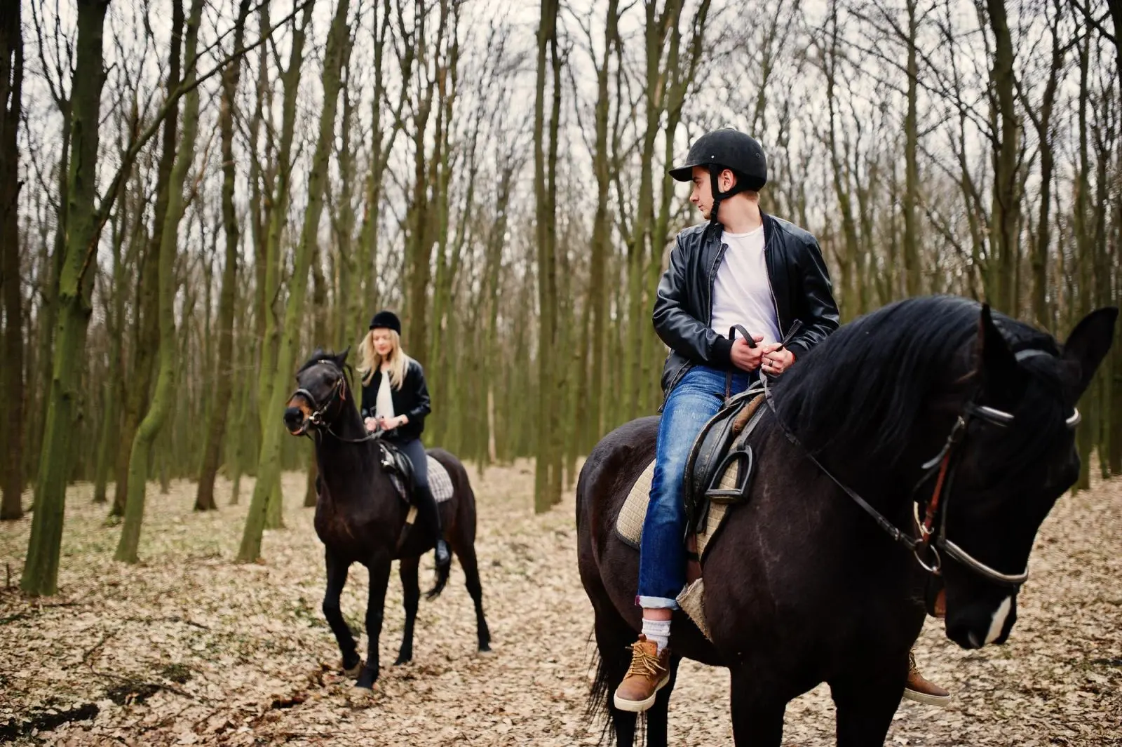 couple riding horses in forest
