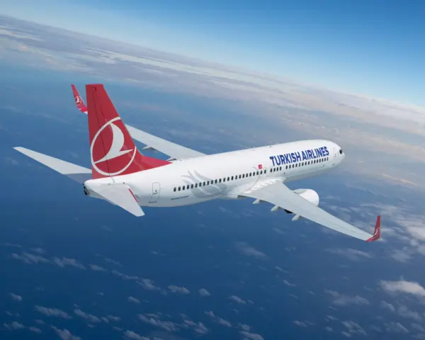 Turkish Airlines Boeing 737 aircraft flying high above the clouds, featuring the airline’s distinctive red and white logo on the tail fin.