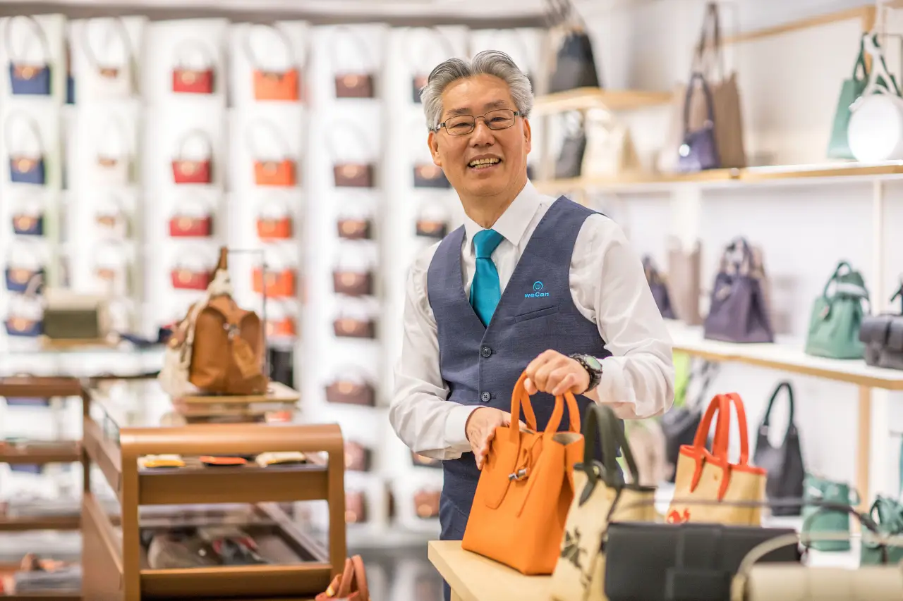 A Chinese customer service man helps Chinese travelers at Munich Airport bag shop