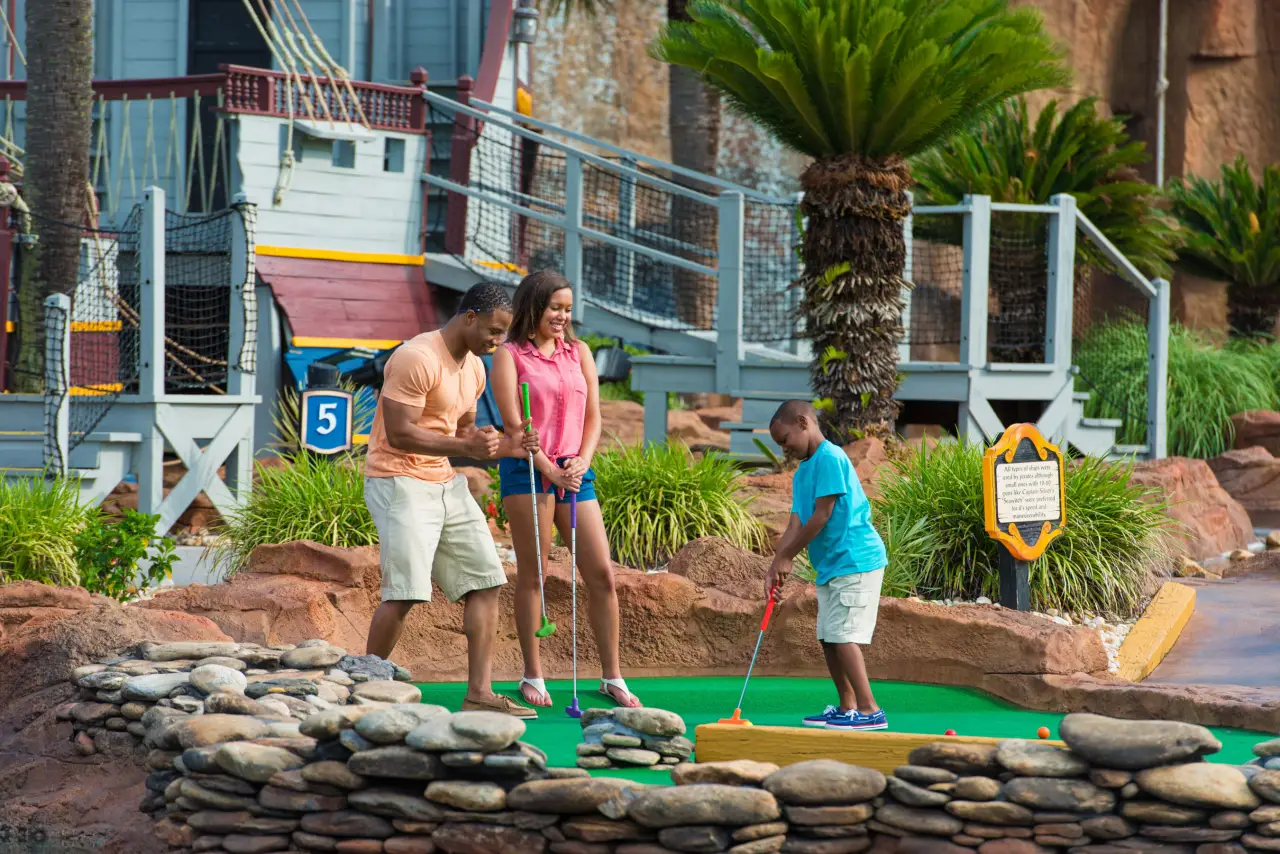 Child plays mini golf with his parents in Myrtle Beach