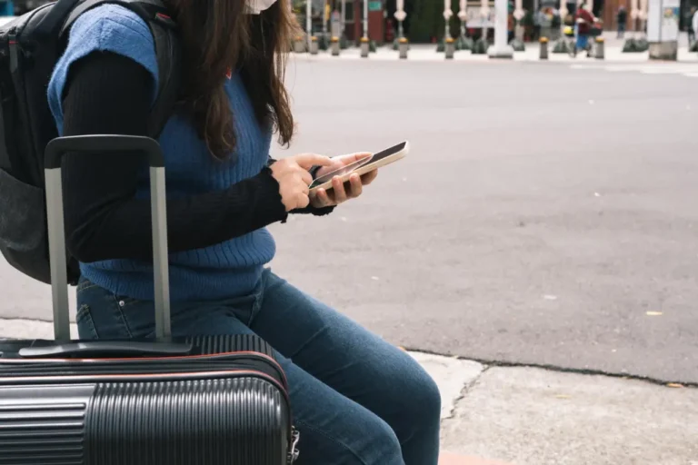 Other News 12 Woman traveler with her luggage searching an address using mobile phone
