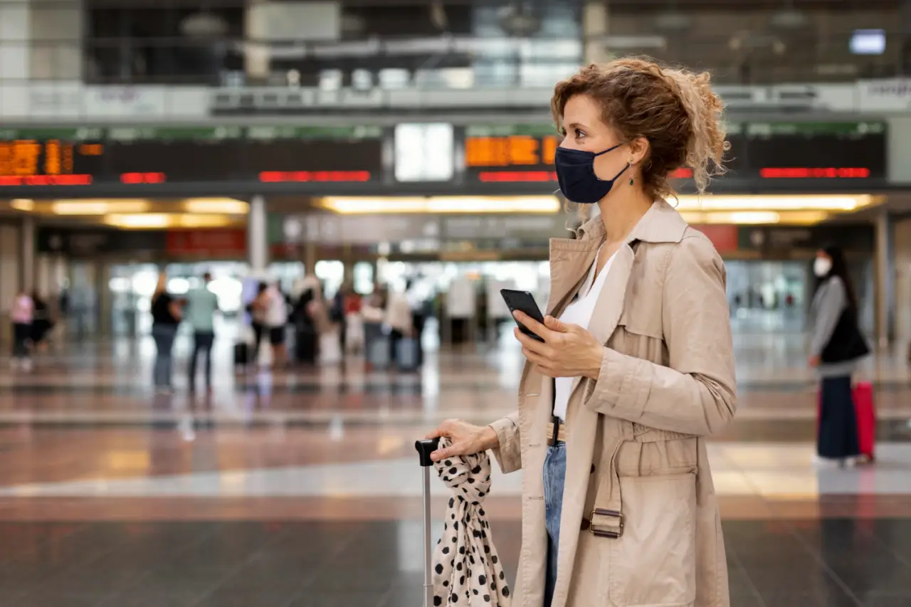 traveling woman in a central station wears mask