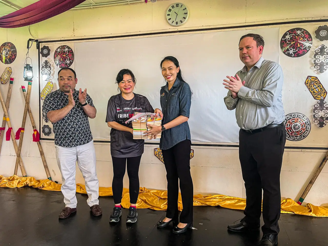 Amelia Roziman presents the books to Michelle Lee, Senior Assistant of Student Affairs