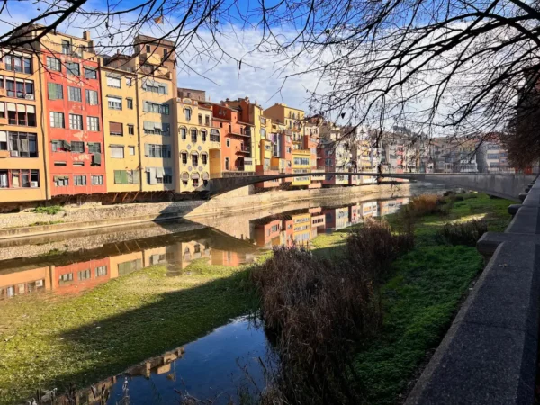 Girona's Onyar river, colorful apartments on shore pedestrian bridge connects two sides
