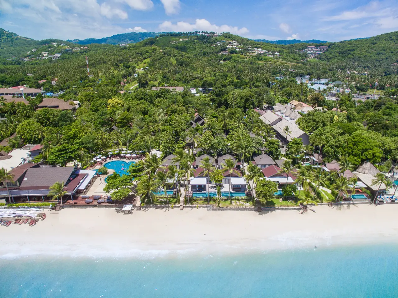 Aerial view of NH Collection Samui with green nature behind the buildings and beach and sea in front