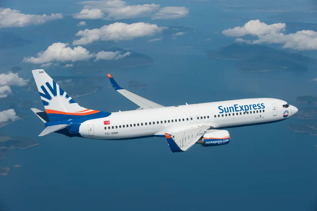 SunExpress Boeing 737-800 aircraft flying over clouds and sea