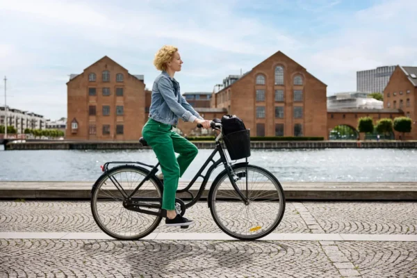 Home 11 Woman is biking in Copenhagen by the canal