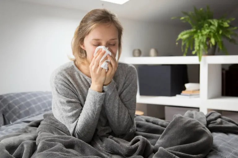 woman flu sneezing in bed