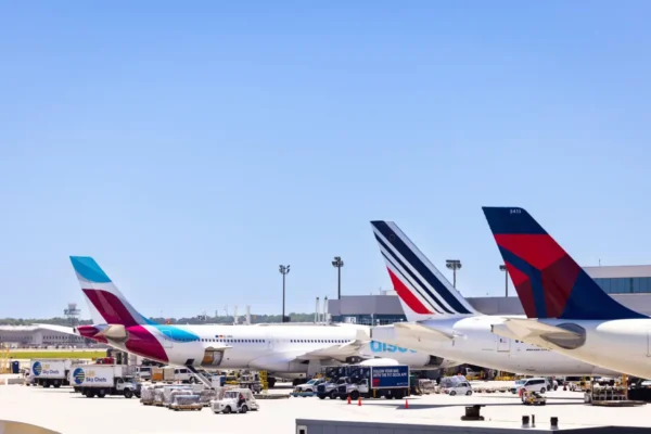 Airplane tails of Eurowings, Air France, and Delta Air Lines at Hartsfield-Jackson Atlanta International Airport terminal under clear blue skies.