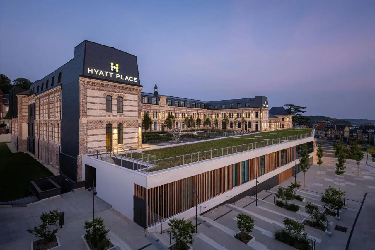 Exterior view of Hyatt Place Rouen during the evening, showcasing the historic building’s brick facade and modern architectural additions.