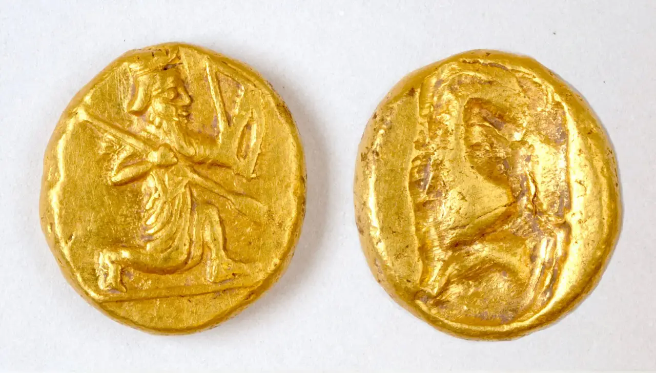 Two ancient Persian gold coins discovered in Turkey, featuring the image of a kneeling Persian king holding a bow and spear.