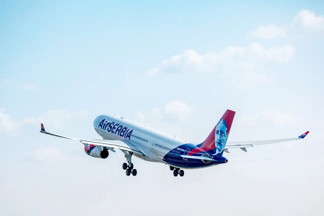 Air Serbia aircraft taking off, featuring the airline’s branding and a portrait on the tail, symbolizing the airline’s growing network and increased passenger numbers.