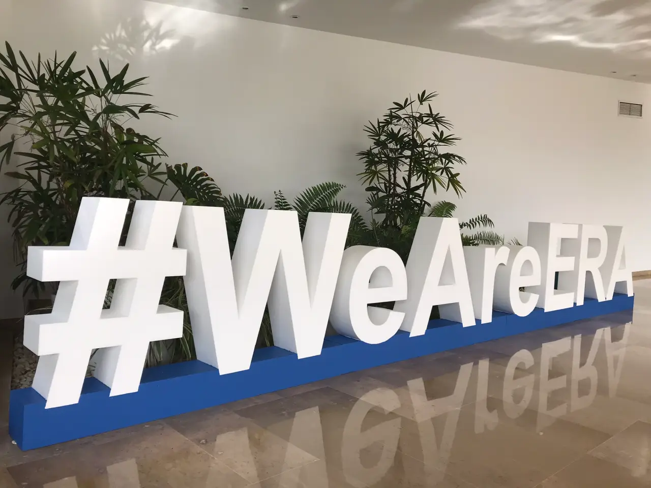 Apg Airlines And Luxair Re-Elected To The Era Board 2 #WeAreERA sign at the European Regions Airline Association event, with greenery in the background.