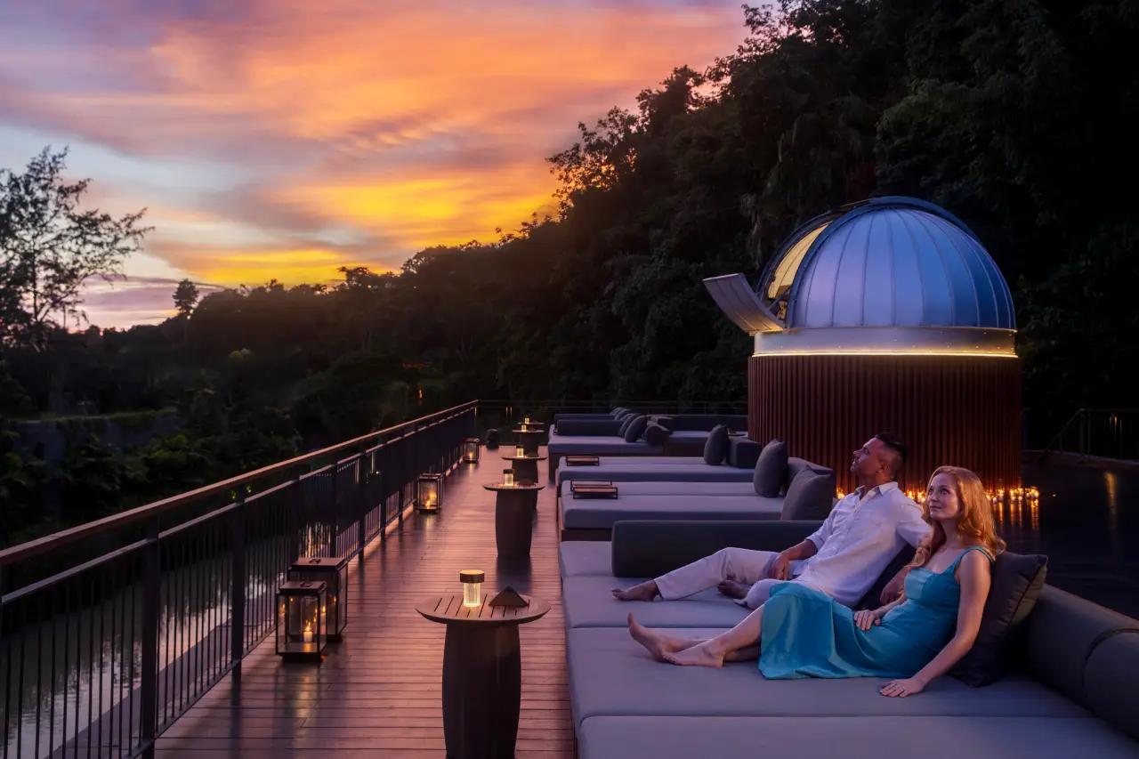 Couple stargazing at sunset on a rooftop lounge at Anantara Layan Phuket.