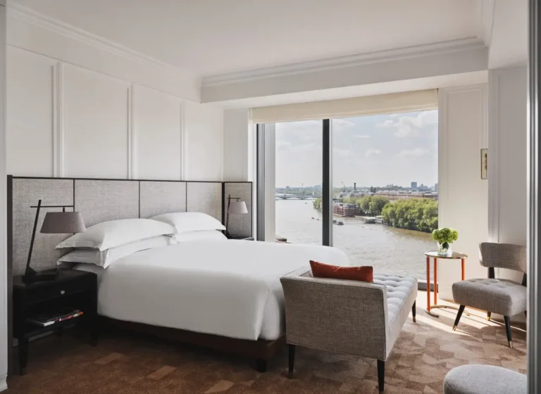 Deluxe King Bed Suite at Park Hyatt London River Thames featuring a plush king-sized bed, elegant furnishings, and floor-to-ceiling windows with stunning views of the River Thames.