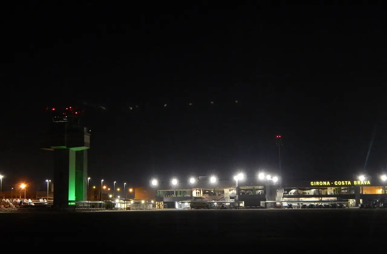 Night view of Girona-Costa Brava Airport terminal and control tower.