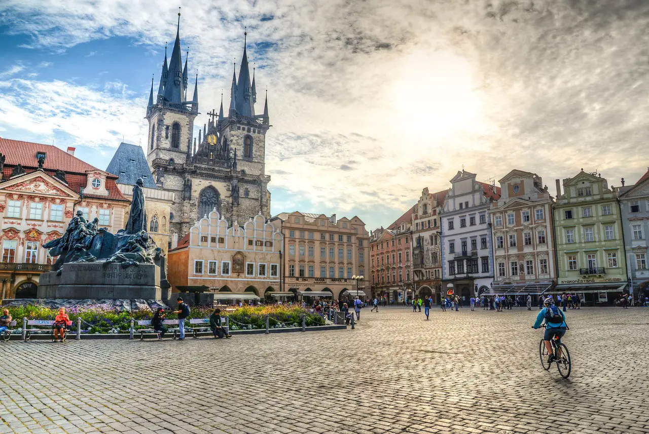 View of Prague’s Old Town Square with the Church of Our Lady before Týn, historic buildings, and people walking in the square.