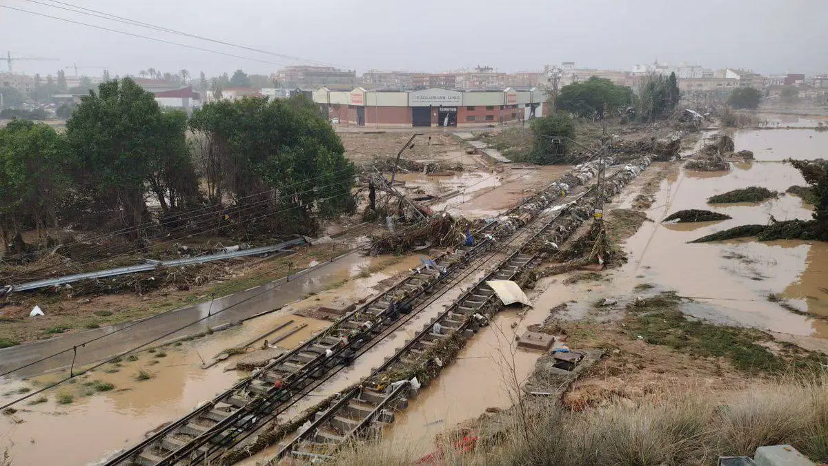 Flood-damaged railway tracks in Valencia, Spain, submerged in water after severe storms.