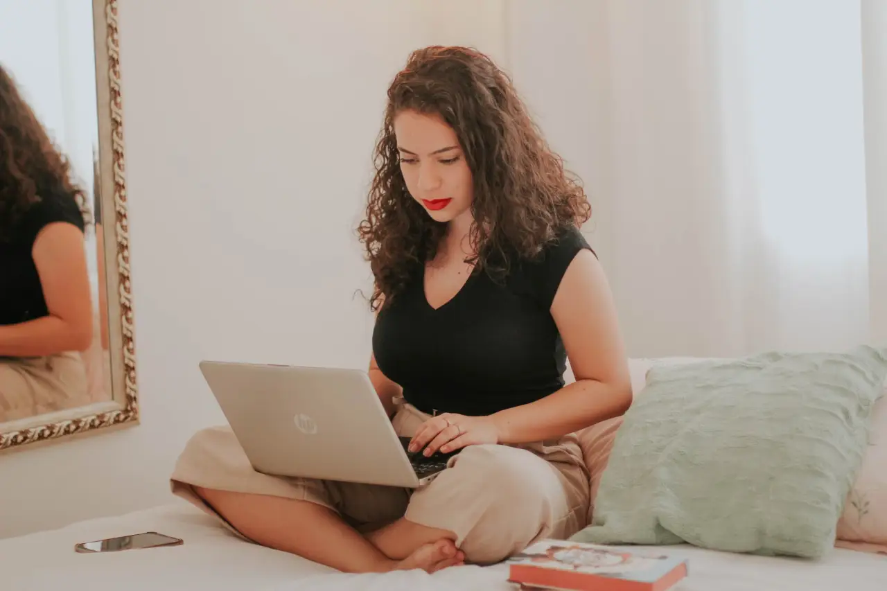 woman working on laptop bed