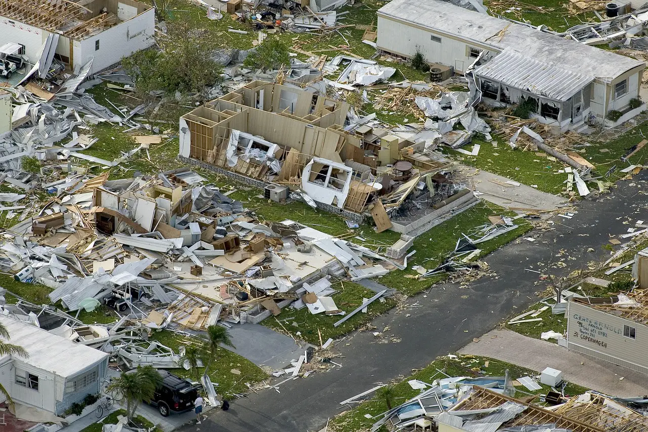 Aerial view of extensive hurricane damage to residential homes with debris scattered across the area.