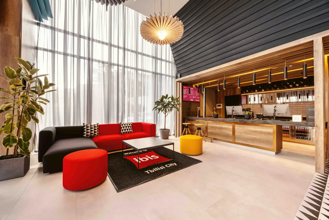 Modern lobby area of ibis Tbilisi City hotel with stylish seating and reception.