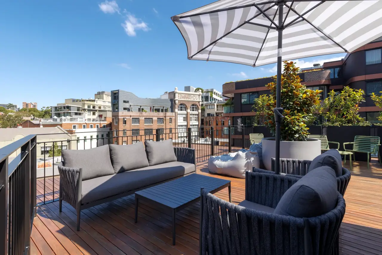 The Allure Of Hotel Book Boutique: The Ultimate Get Away 2 Rooftop terrace at 202 Elizabeth boutique hotel with modern seating, striped umbrella, and city skyline view.