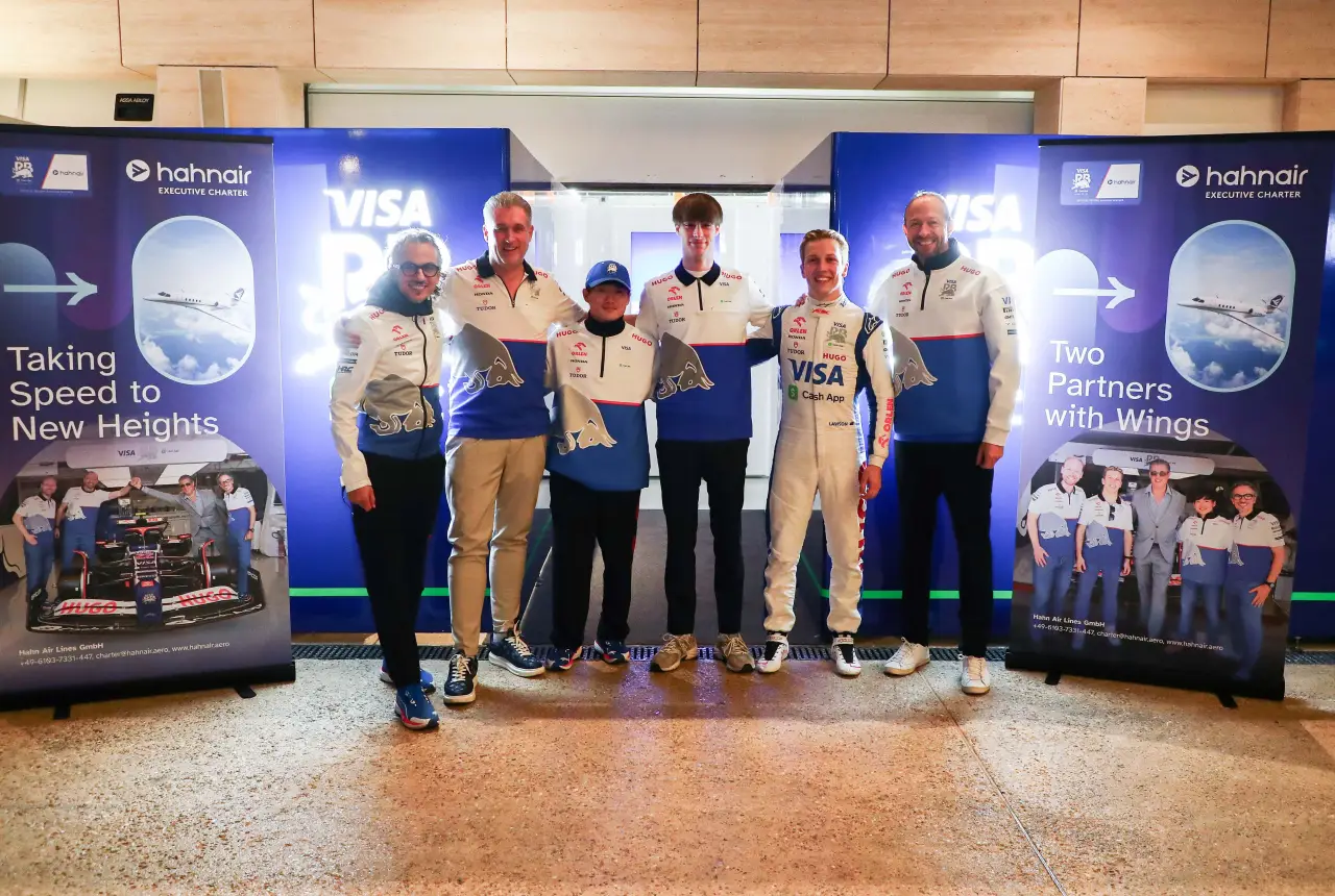 Formula 1 Team Partners With Hahnair Aviation 14 Group photo of Visa Cash App RB Formula 1 team members alongside representatives of Hahnair Executive Charter, standing in front of branded banners showcasing their partnership.