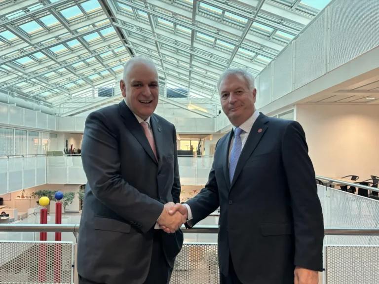 Two Star Alliance executives shaking hands inside a modern glass-ceiling building.