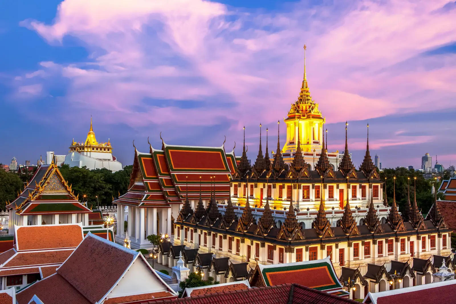 The stunning Loha Prasat Temple in Bangkok, Thailand, illuminated at sunset.