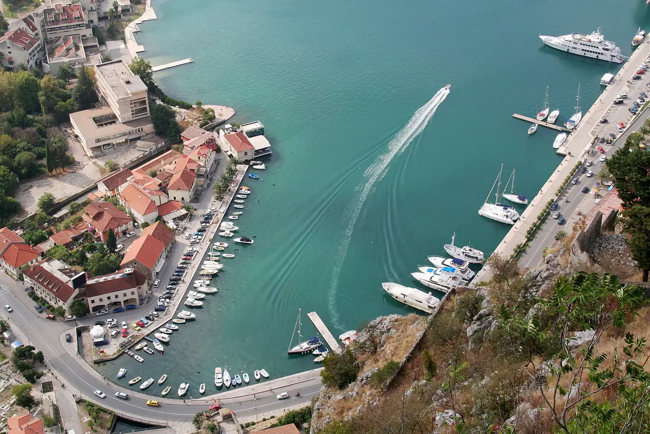 The Ultimate Road Trip Through The Balkans 2 Aerial view of boats docked along the Bay of Kotor with surrounding historic buildings.