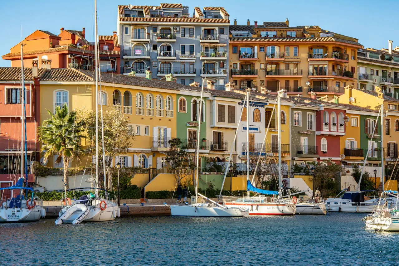 Colorful Mediterranean-style houses and docked boats at Port Saplaya, Valencia, Spain.