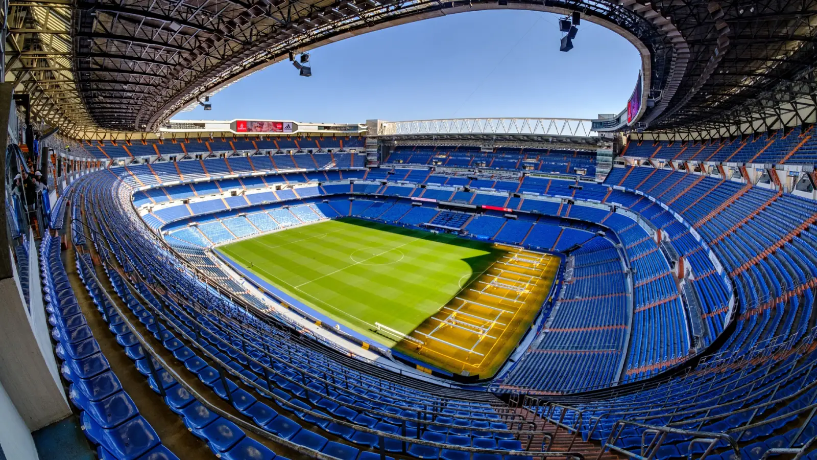 Madrid Hosts 3Rd World Sports Tourism Congress At Santiago Bernabéu 2 Panoramic view of the Santiago Bernabéu Stadium in Madrid, showcasing its blue seats and green field under a clear sky.