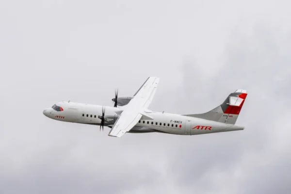 ATR 72 aircraft in flight, showcasing its sleek design against a cloudy sky