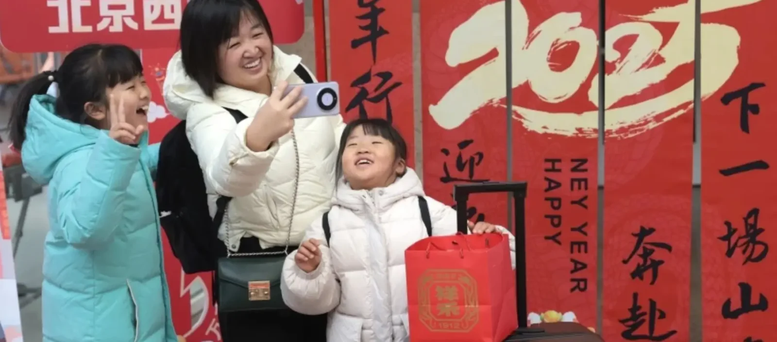 A smiling Chinese family taking a selfie in front of festive Spring Festival decorations with red banners.