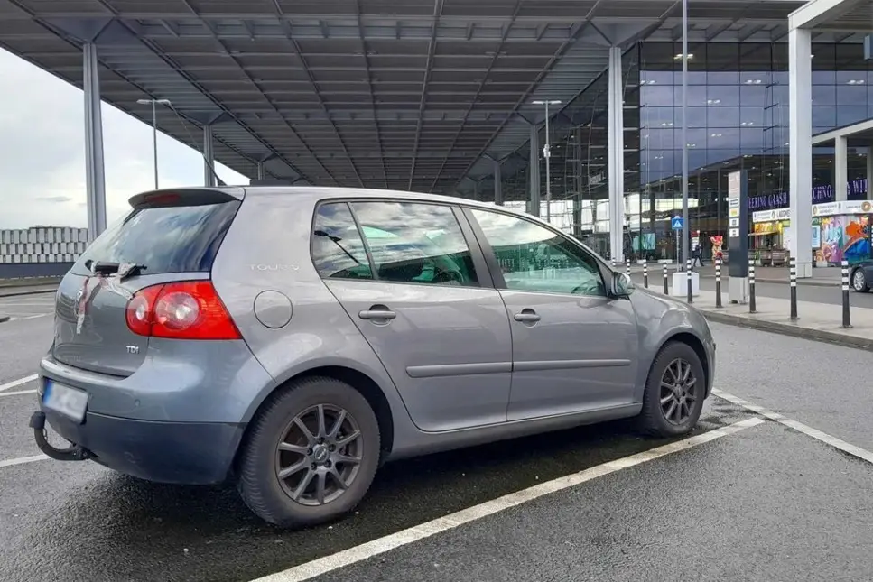 Abandoned Volkswagen Golf parked outside Berlin-Brandenburg Airport.
