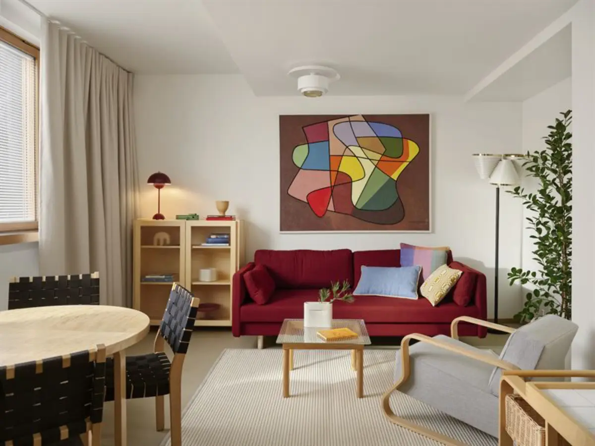A stylish living room in Finlandia Hall’s new apartments, featuring Alvar Aalto-inspired design, vibrant artwork, and modern furnishings.