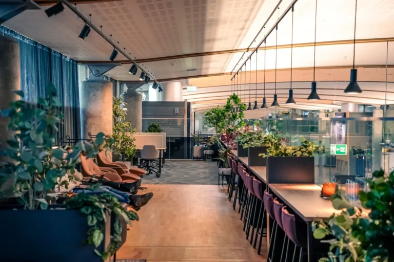 Modern airport lounge at Oslo Gardermoen Airport with lush greenery and cozy seating.