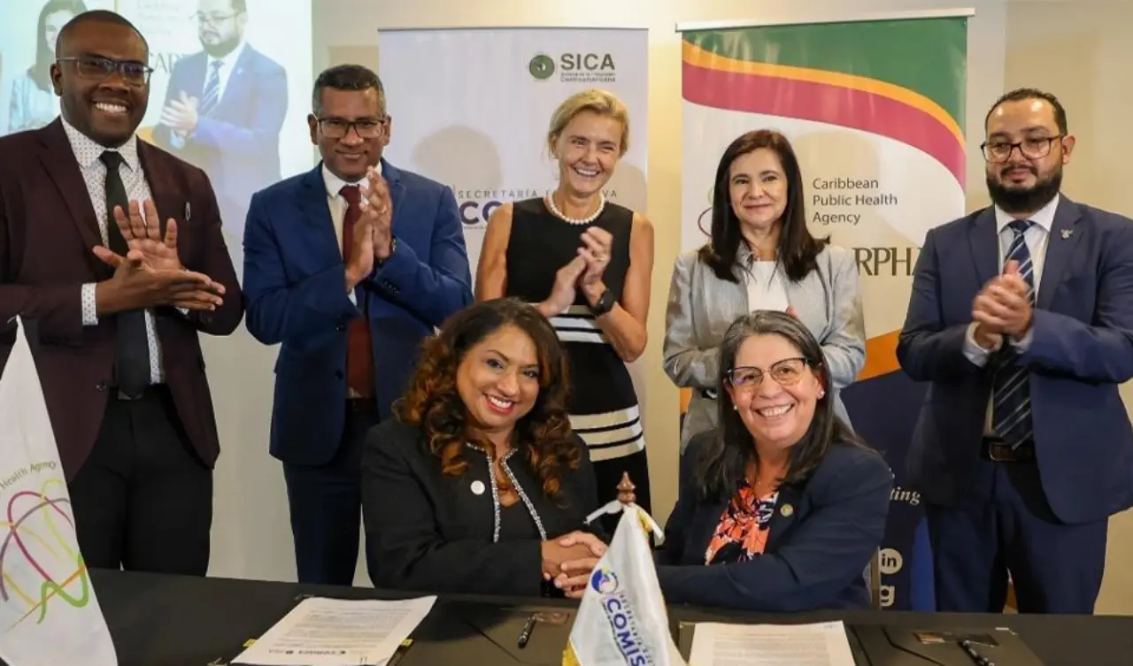 CARPHA and SE-COMISCA leaders signing the MOU to enhance health cooperation between the Caribbean and Central America, with officials from both organizations present.