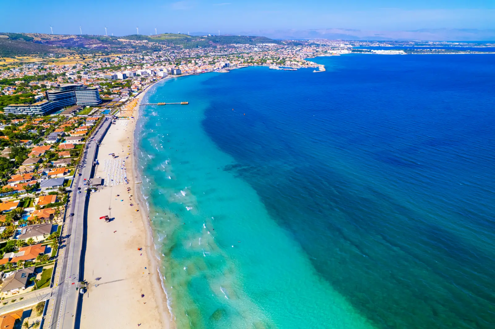 A stunning aerial view of Ilıca Beach in Alaçatı, Çeşme, İzmir, with turquoise waters, golden sand, and a lively coastline.