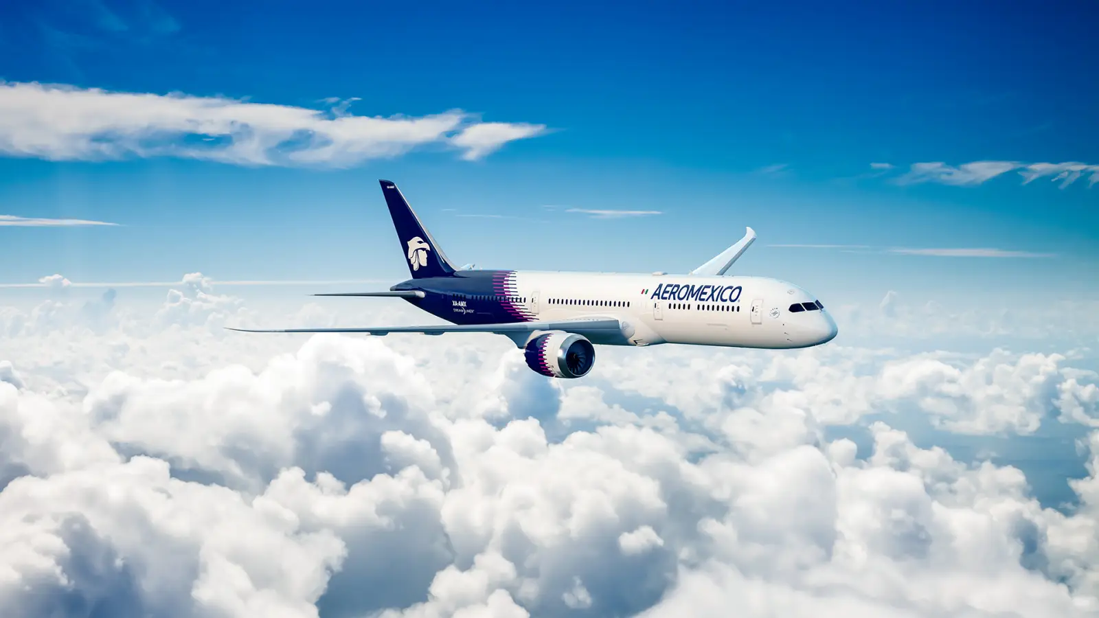 Aeromexico Boeing 787 Dreamliner flying above the clouds with a blue sky background.