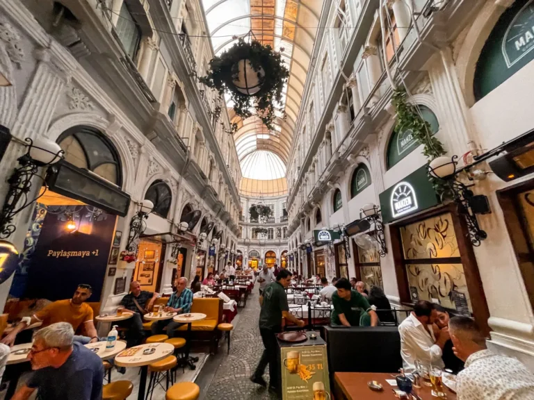 A lively scene inside Istanbul’s historic Çiçek Pasajı, where locals and tourists enjoy dining and drinks in a traditional Turkish atmosphere.
