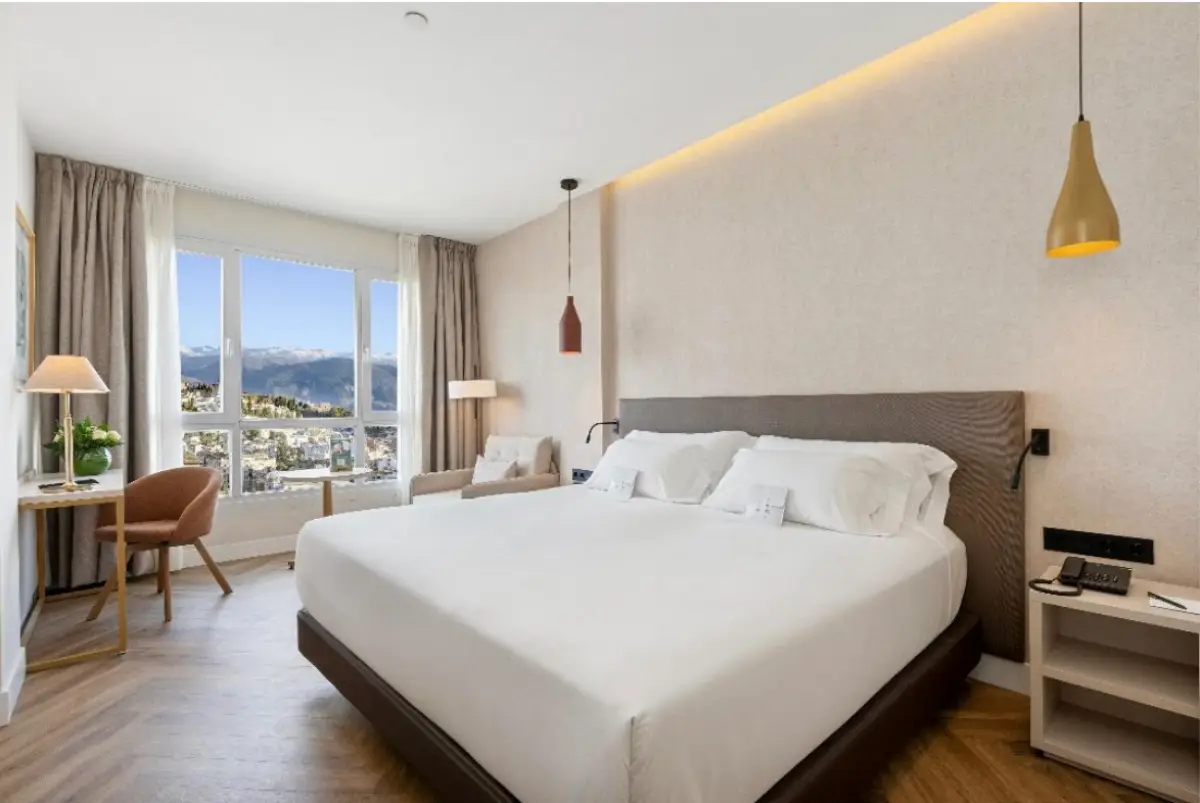 Modern hotel room at Sercotel HMO Martina Granada with large bed and mountain views