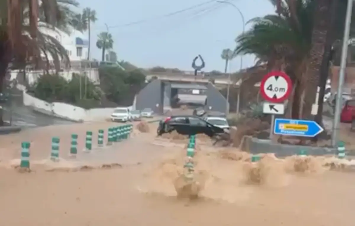 A flooded street in Telde, Gran Canaria, with muddy waters carrying away cars after heavy rainfall.