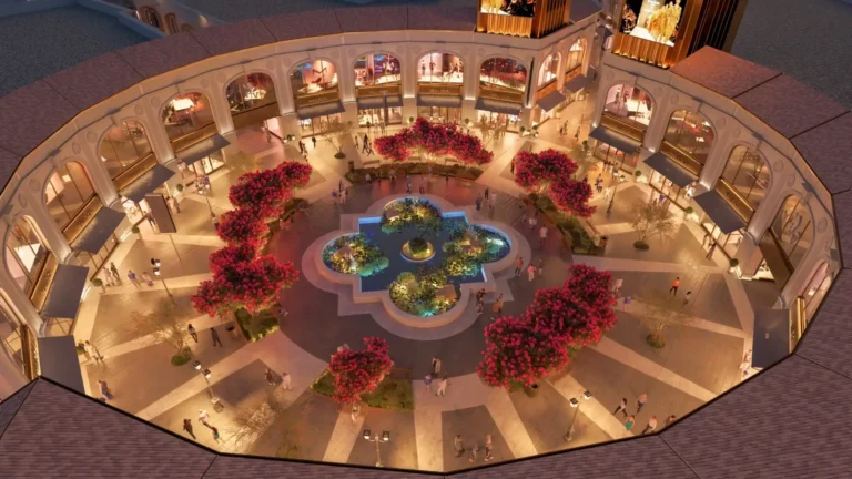 A luxurious open-air shopping center with a central fountain, elegant architecture, and vibrant landscaping at Florentia Village in Istanbul.