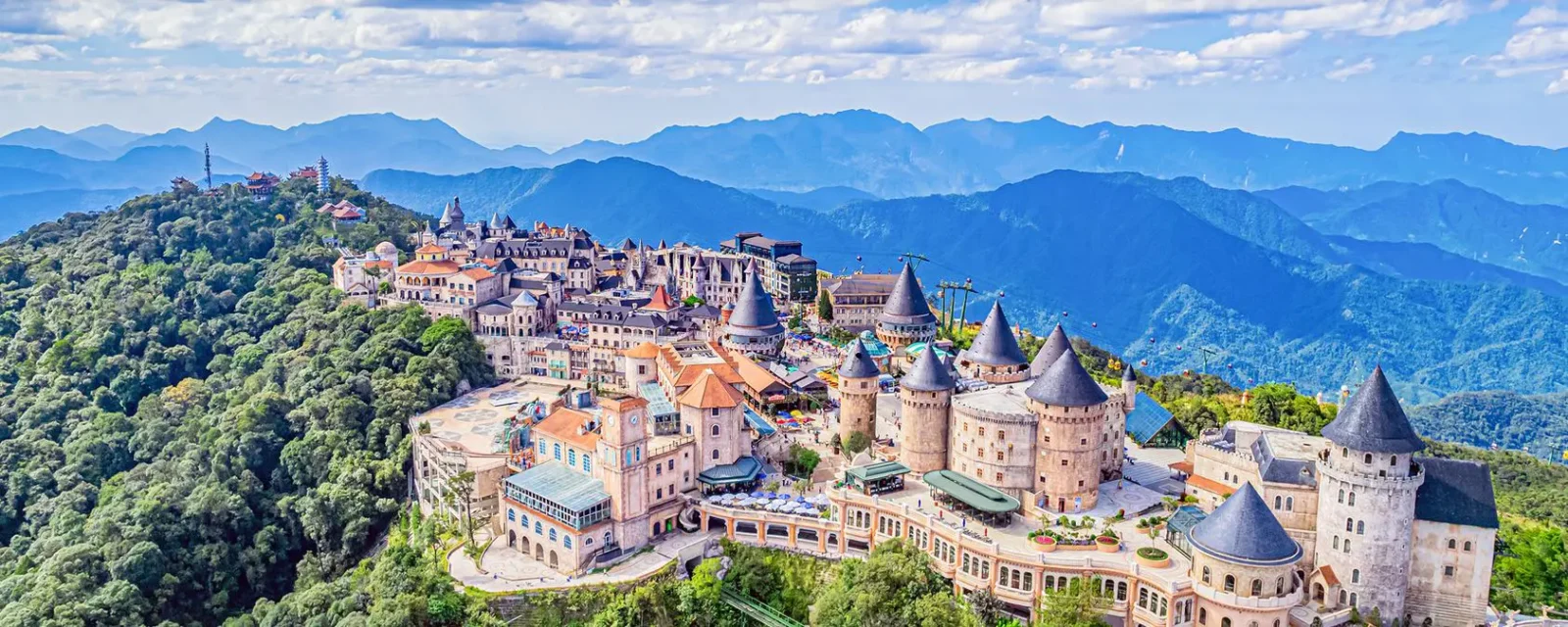 A Resort In The Clouds - Ba Na Hills In Vietnam 7 A panoramic view of the French Village in Ba Na Hills, Vietnam, showcasing medieval-style castles, vibrant streets, and lush mountain landscapes.