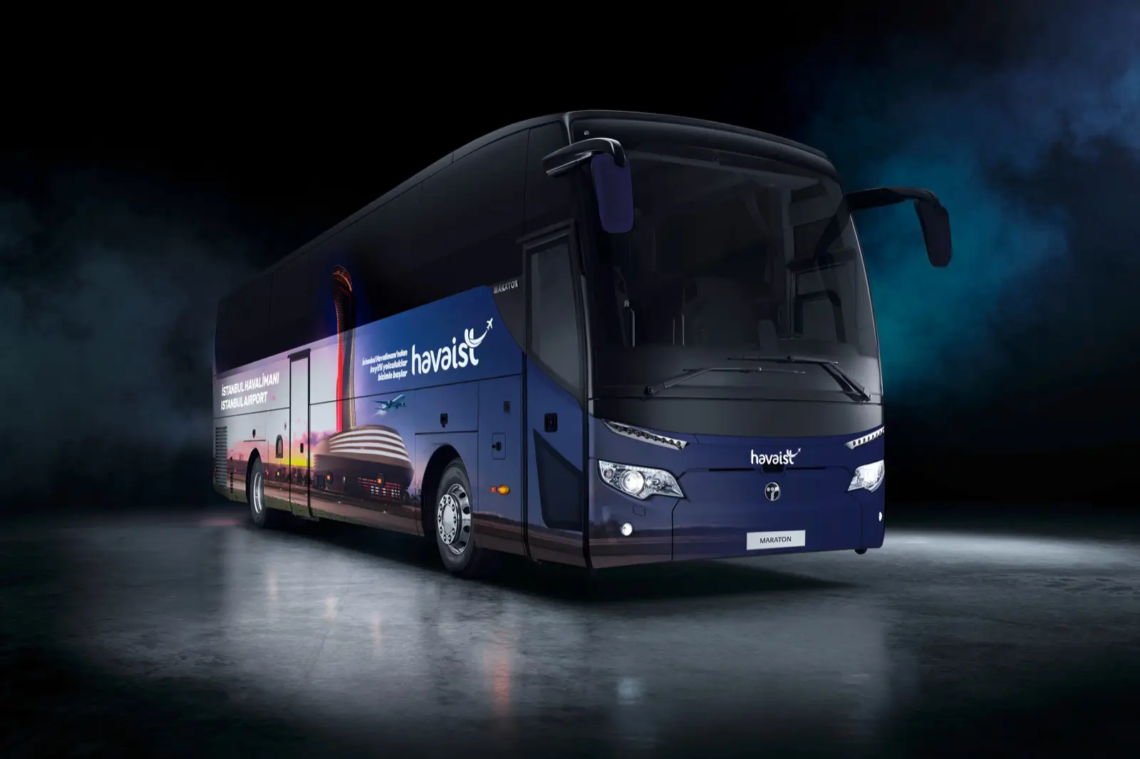 A modern Havaist airport shuttle bus with a sleek design and Istanbul Airport branding, parked in a dimly lit setting with blue and black background tones.