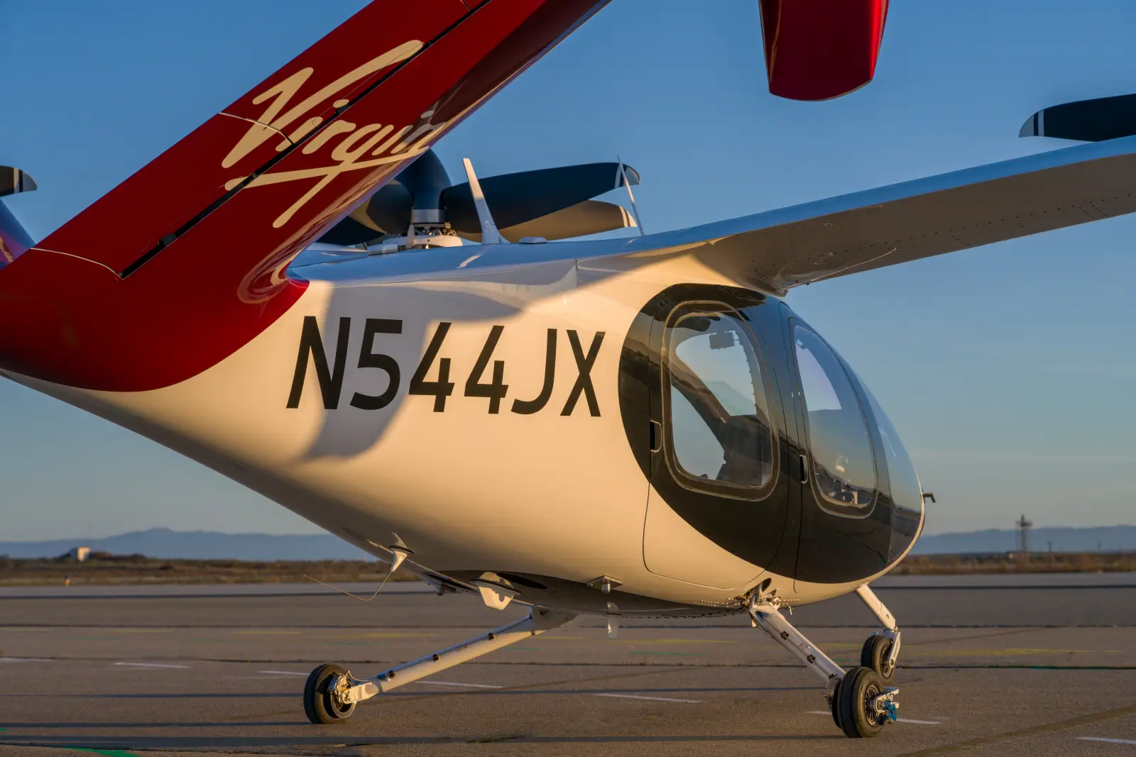 A Joby Aviation electric air taxi featuring Virgin Atlantic branding on its tail, parked on a runway.