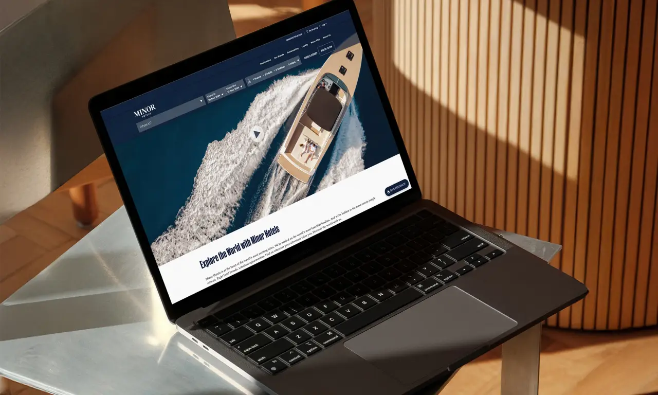 Minor Hotels Launches New Masterbrand Strategy 9 Laptop displaying the redesigned Minor Hotels website with a luxury boat image on screen.